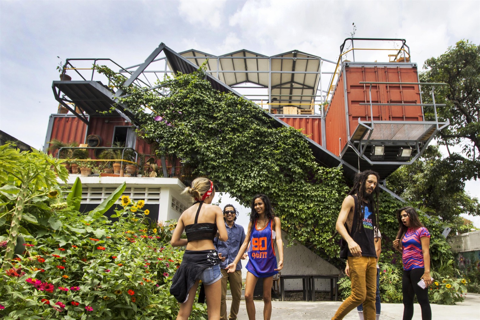 People near innovative container architecture with greenery.