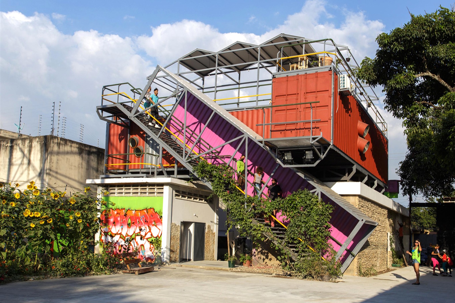Colorful shipping container building with stairs and graffiti.