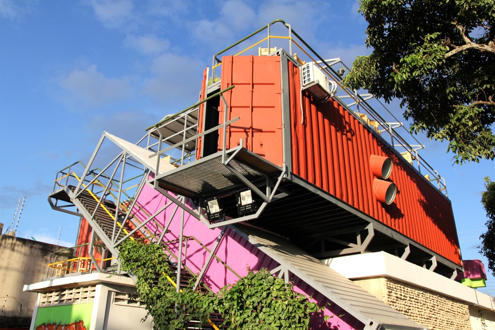 Colorful shipping container architecture with stairs and trees