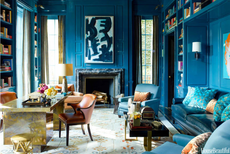 Elegant blue living room with fireplace and bookshelves.