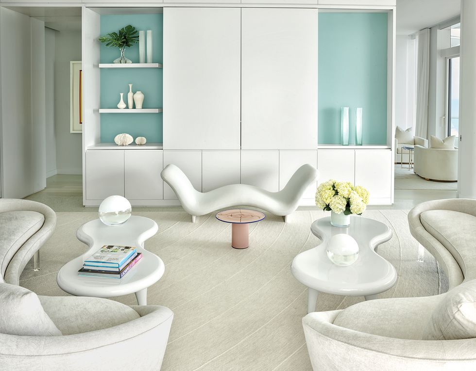 Modern living room with stylish white furniture and decor.