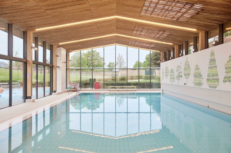 A swimming pool, enhanced by glass walls.