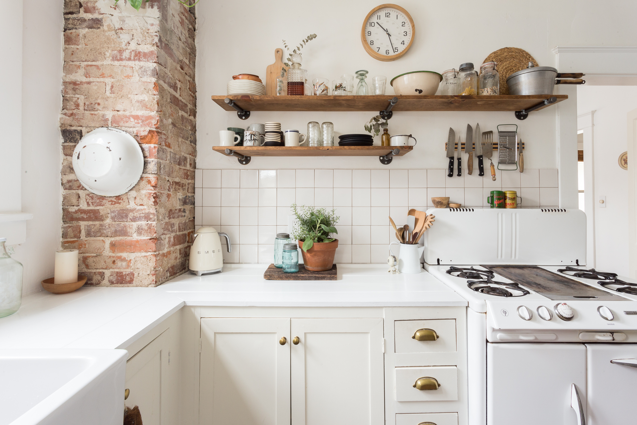 Cozy kitchen interior with utensils and exposed brick.
